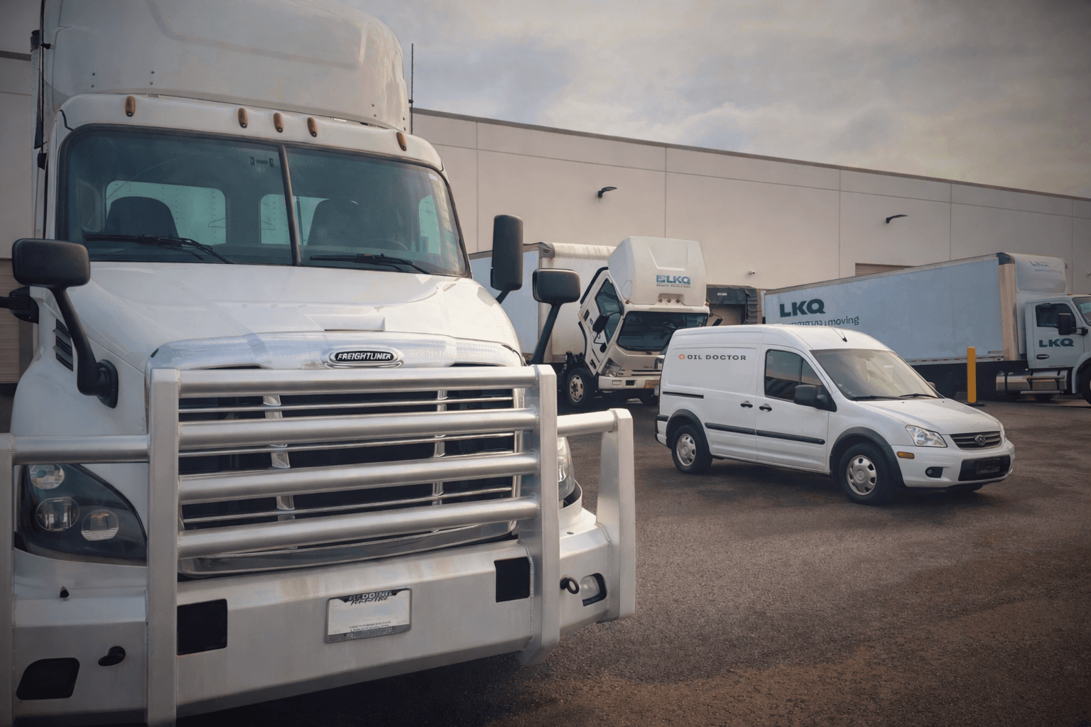 An Oil Doctor van servicing box trucks at a commercial fleet yard